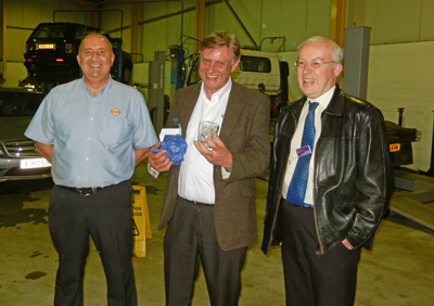 John Mackie (centre) having been presented with a Scottish Region engraved glass by Douglas Norris (right). John Connachan, the Service Manager is on the left.